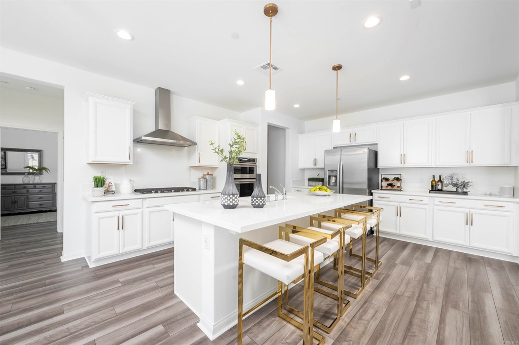 33288 Skyview Road Winchester, CA 92596 - Photo 9 of 51 a kitchen with stainless steel appliances granite countertop a sink stove a refrigerator and white cabinets with wooden floor