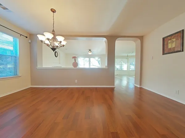 a view of a livingroom with wooden floor and a chandelier