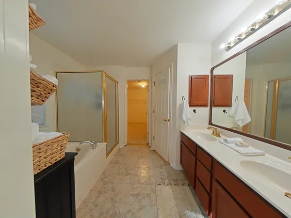 a spacious bathroom with a double vanity sink mirror and shower