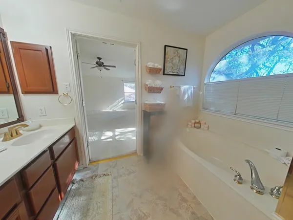 a bathroom with a tub sink and mirror