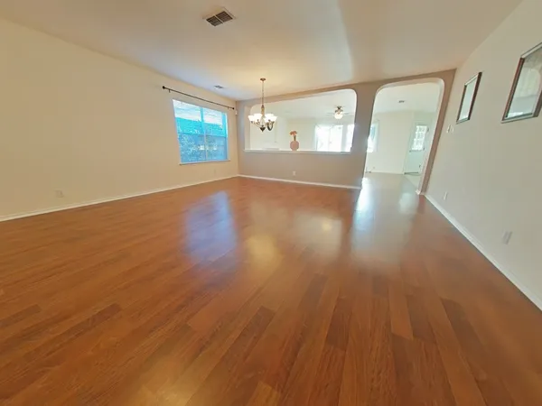 a view of a big room with wooden floor and windows