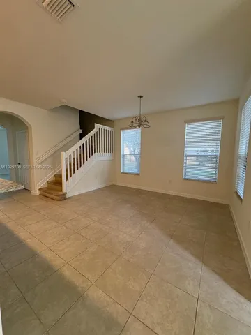 a view of an empty room with stairs and a window