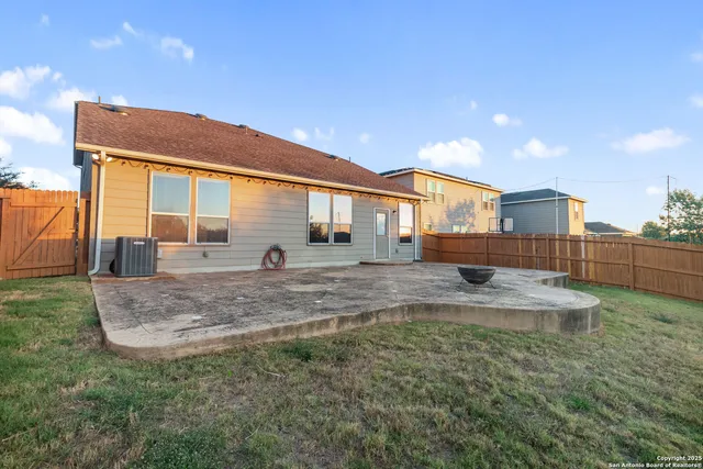 a view of a house with a backyard and a tree