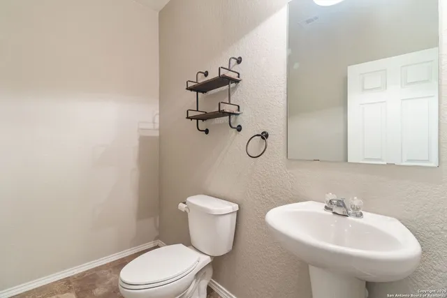 a bathroom with a sink a toilet and mirror