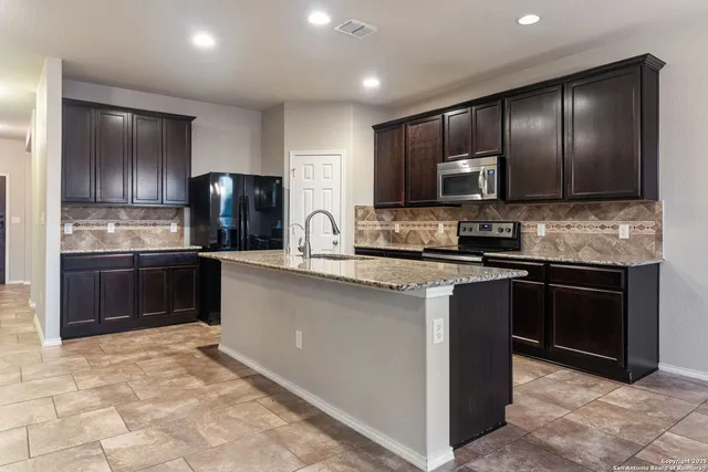 a kitchen with stainless steel appliances granite countertop a refrigerator stove a sink and dishwasher