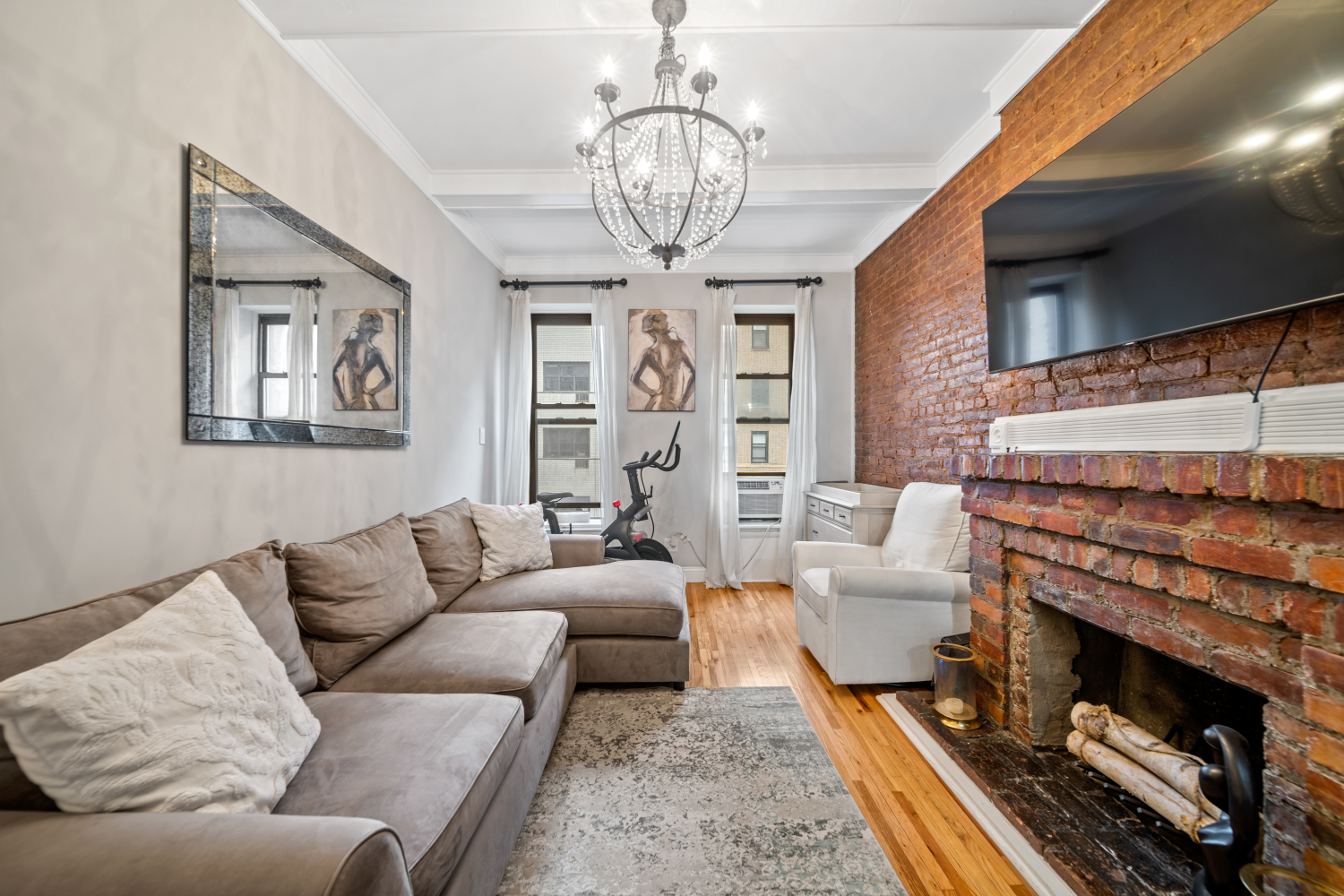 132 West 71st Street, Unit 7 Manhattan, NY 10023 - Photo 2 of 9 a living room with furniture a chandelier and a fireplace