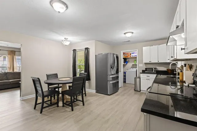 a view of a dining room with furniture and a kitchen view