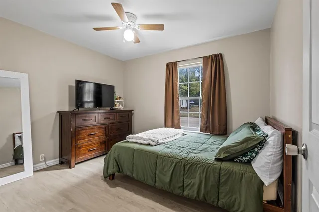 a bedroom with a bed and a flat tv screen on dresser