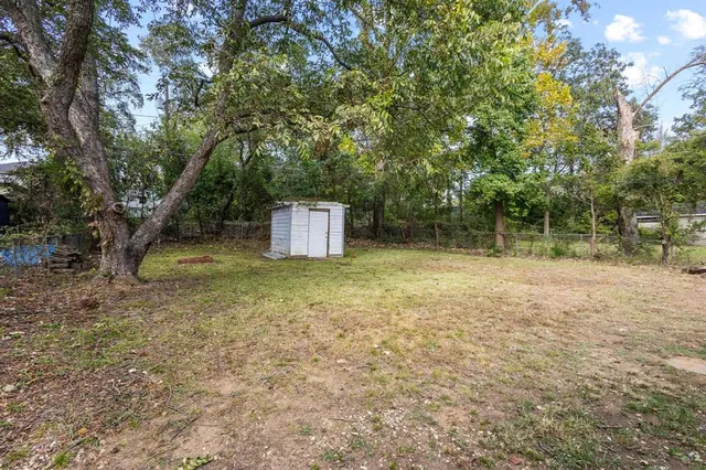 a backyard of a house with trees and swing