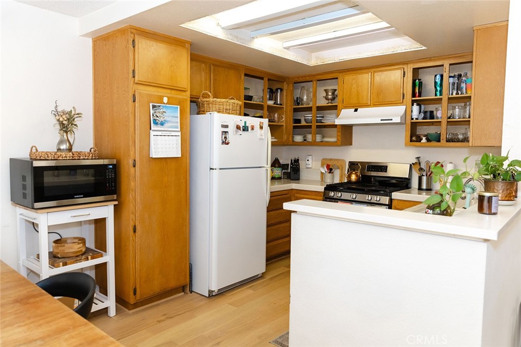 6059 Merion Court Banning, CA 92220 - Photo 18 of 48 a kitchen with stainless steel appliances a refrigerator a stove a microwave and cabinets