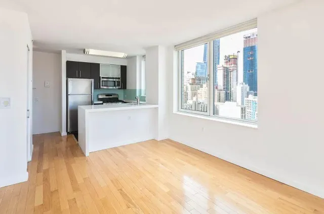 a view of a kitchen with microwave and wooden floor