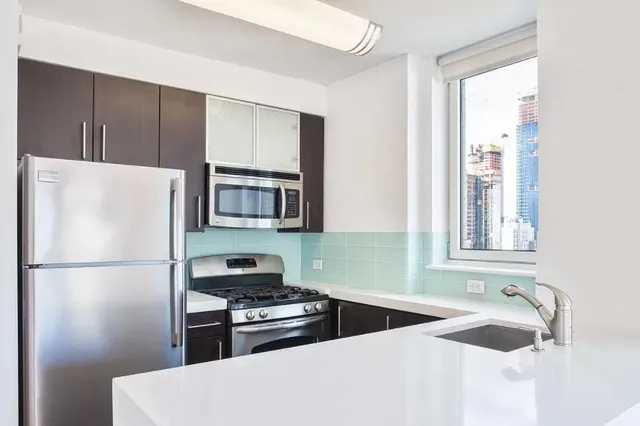 a kitchen with stainless steel appliances granite countertop a refrigerator and a sink