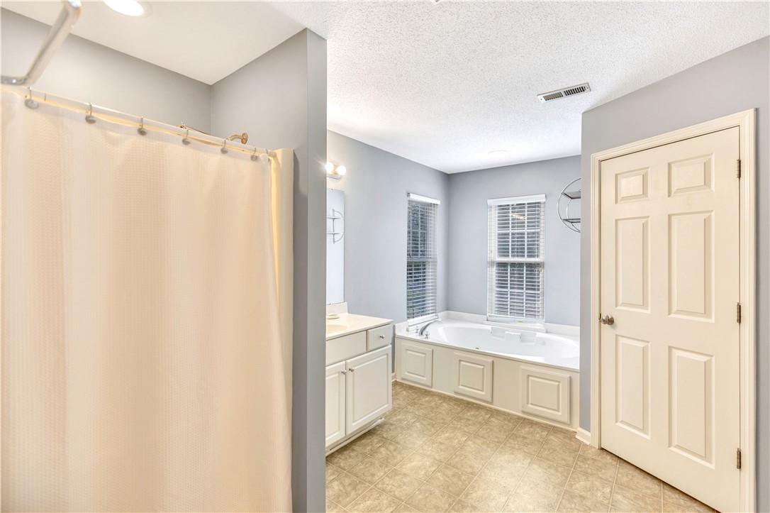 256 Rock Creek Road Clemson, SC 29631 - Photo 19 of 30 This spacious bathroom offers a relaxing soaking tub and ample natural light for serene mornings, as well as access to the laundry.