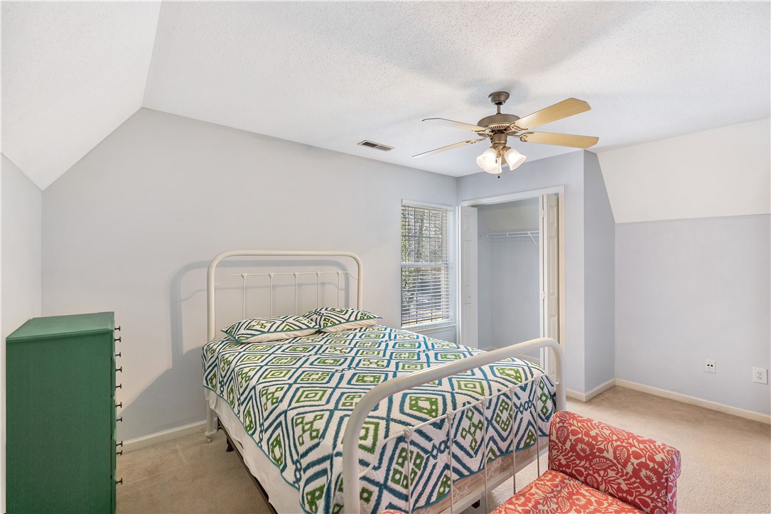 256 Rock Creek Road Clemson, SC 29631 - Photo 24 of 30 This cozy bedroom features a sloped ceiling and carpeted flooring, creating a comfortable and inviting space.