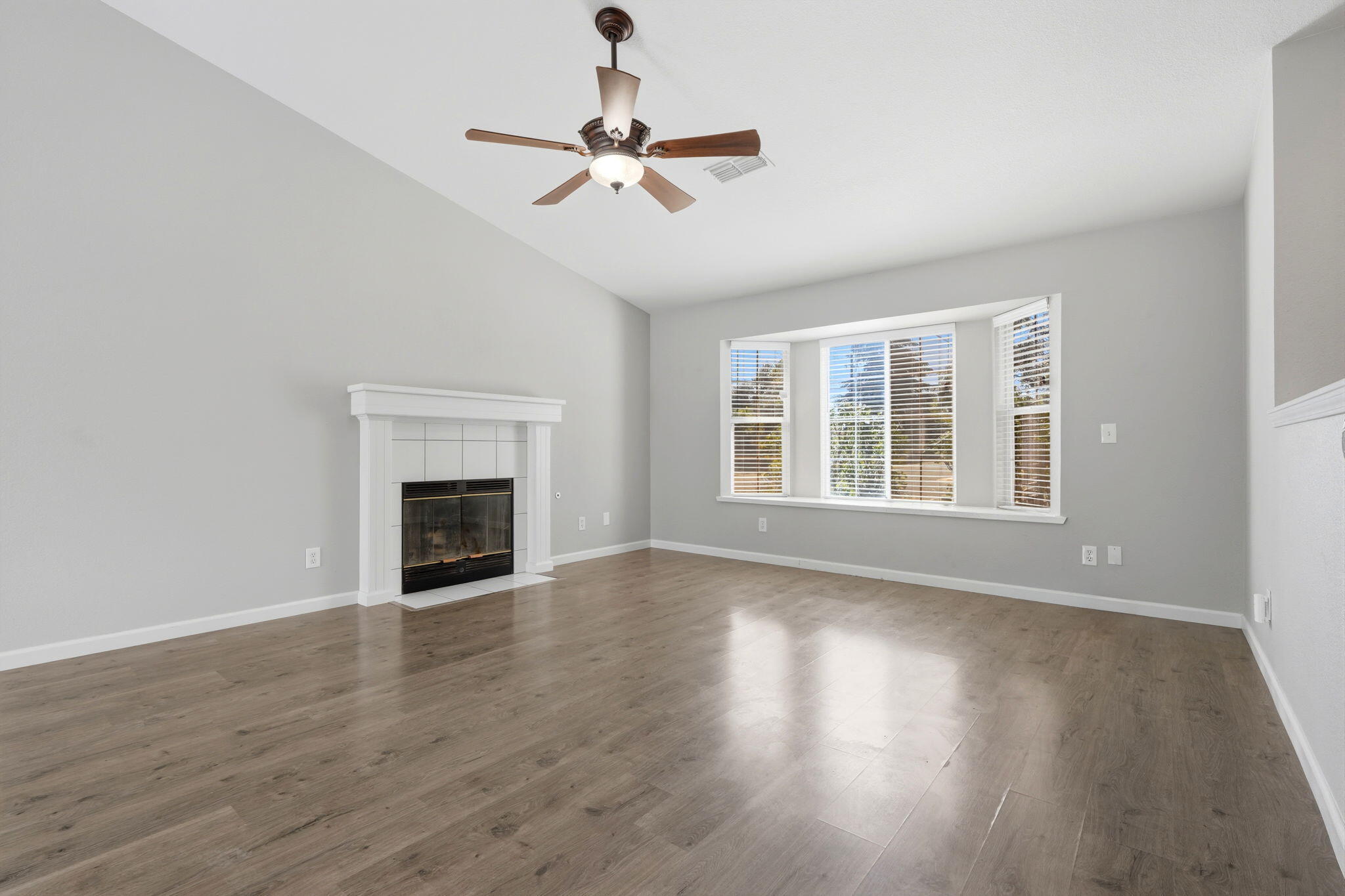 481 Katelyn Court Exeter, CA 93221 - Photo 10 of 33 a view of an empty room with wooden floor fireplace and a window