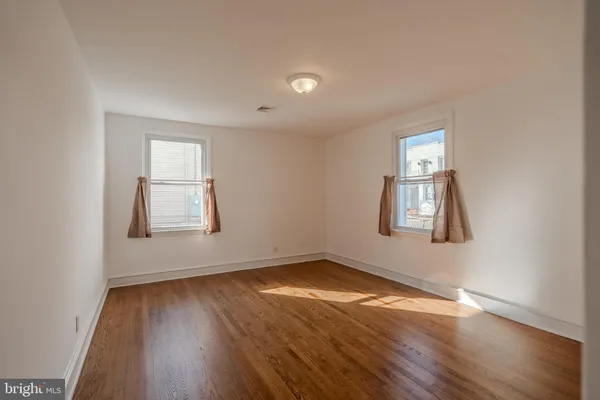 an empty room with wooden floor and a window