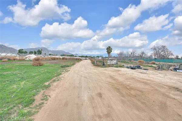a view of road with card parked on the roadside