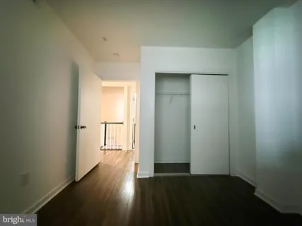 an empty room with wooden floor door and windows