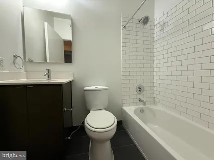 a bathroom with a toilet a sink a mirror a bathtub and shower