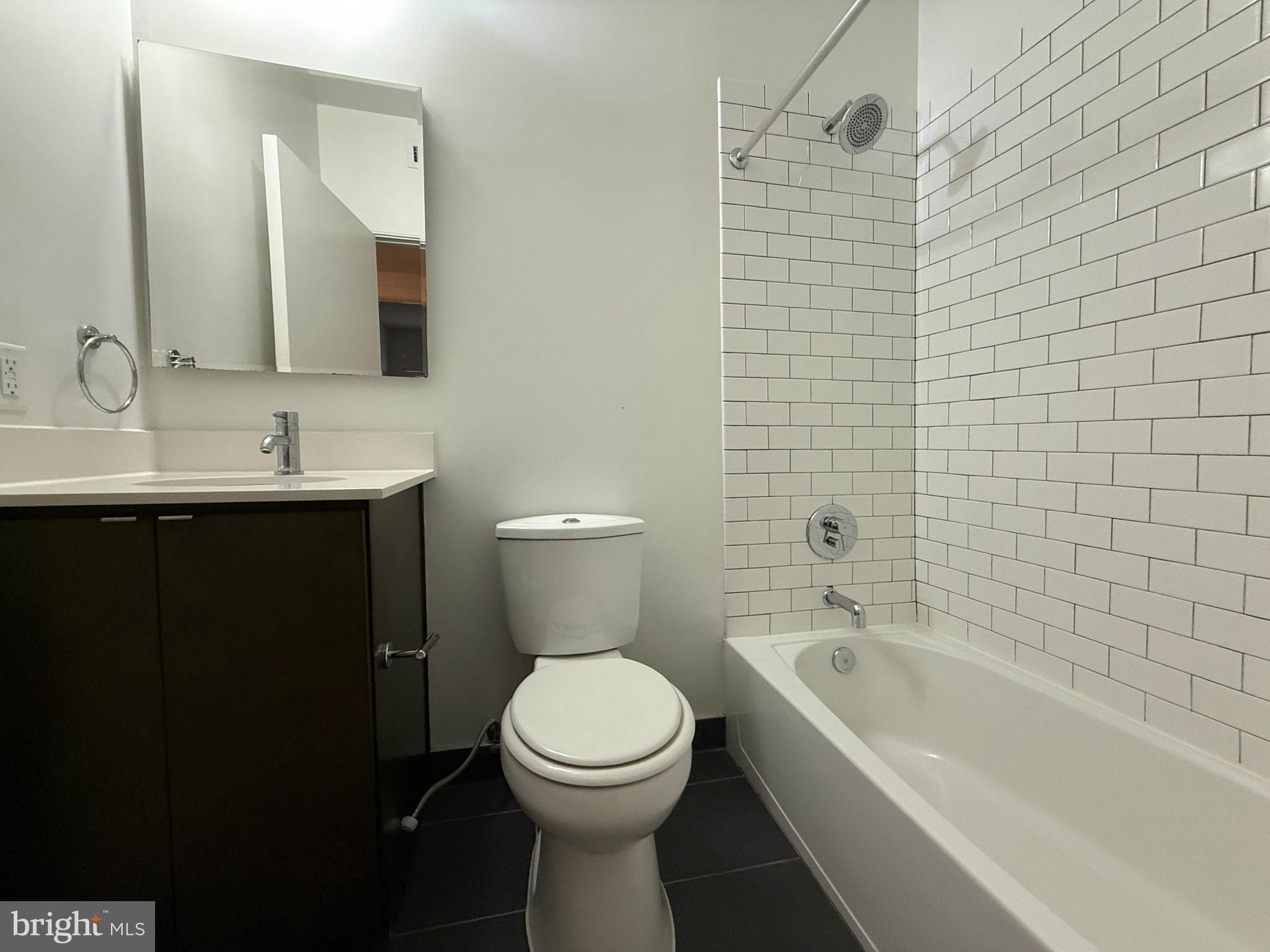 1250 9th Street Northwest, Unit 214 Washington, DC 20001 - Photo 20 of 27 a bathroom with a toilet a sink a mirror a bathtub and shower