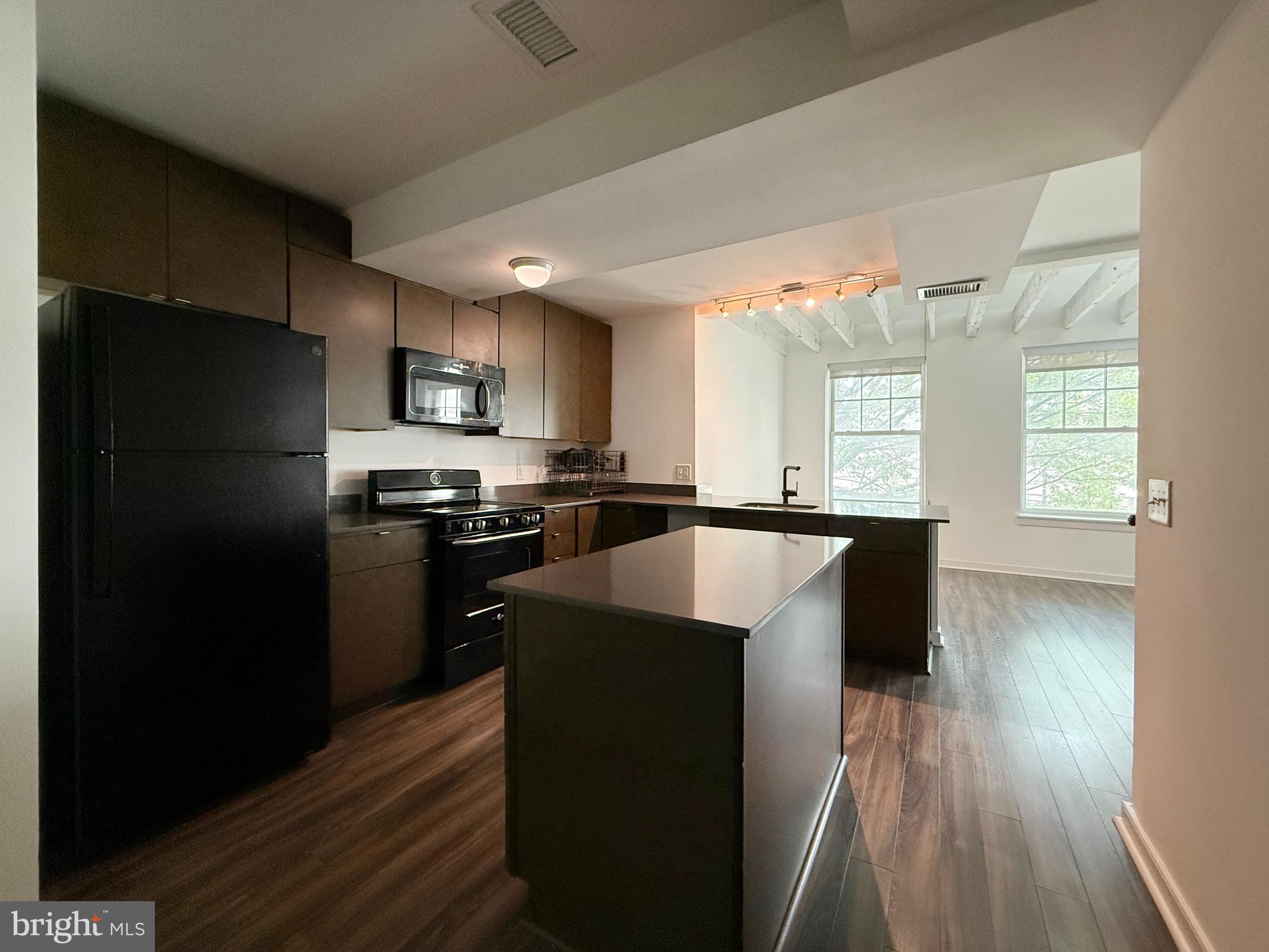 1250 9th Street Northwest, Unit 214 Washington, DC 20001 - Photo 2 of 27 a kitchen with stainless steel appliances granite countertop a refrigerator a sink a stove and oven with wooden floor