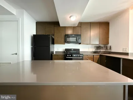 a kitchen with stainless steel appliances a refrigerator sink stove and microwave