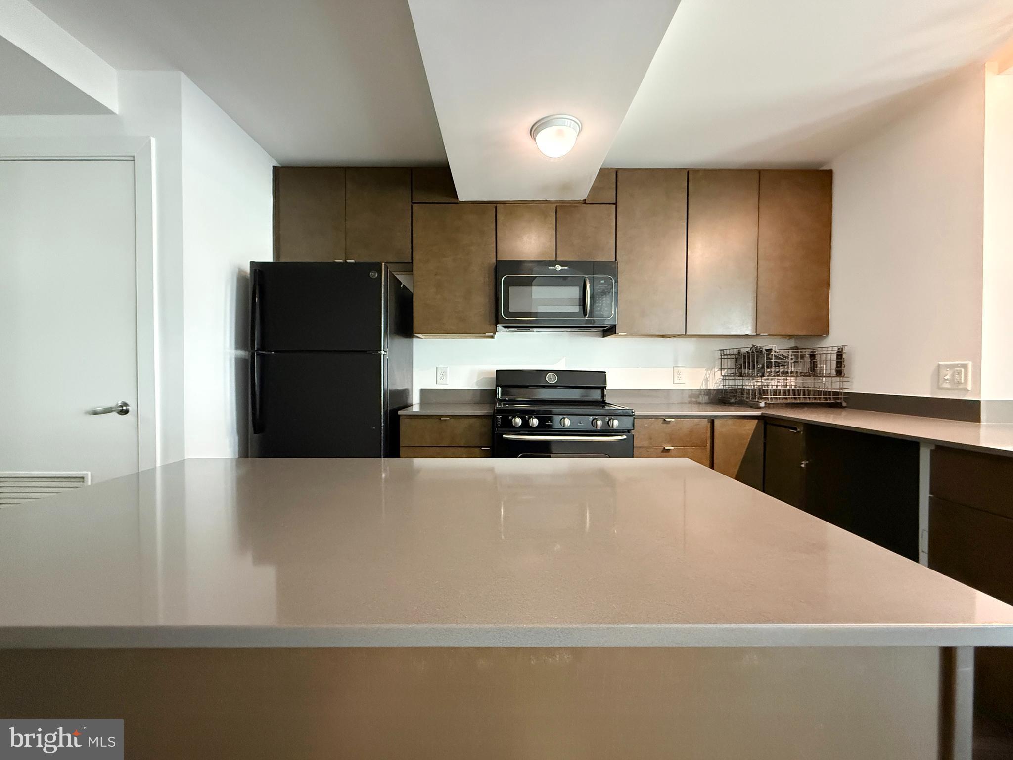 1250 9th Street Northwest, Unit 214 Washington, DC 20001 - Photo 3 of 27 a kitchen with stainless steel appliances a refrigerator sink stove and microwave