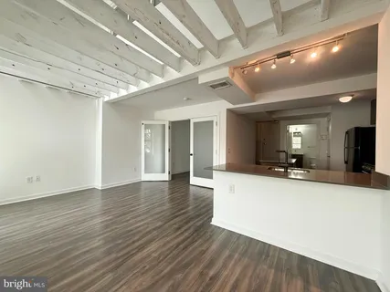 a view of a living room with wooden floor and a flat screen tv