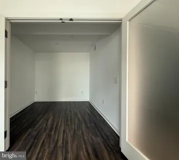 a view of a small space with wooden floor and a window