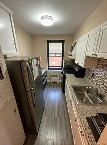a kitchen with sink cabinets and wooden floor