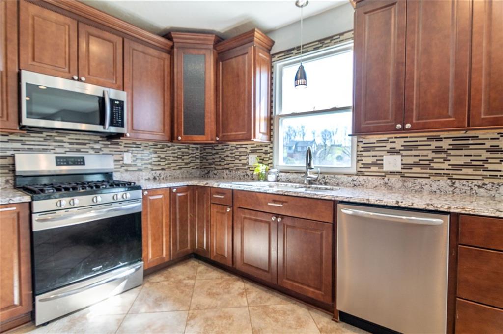 2541 Clay Pike Irwin, PA 15642 - Photo 11 of 36 a kitchen with stainless steel appliances granite countertop a stove microwave and sink