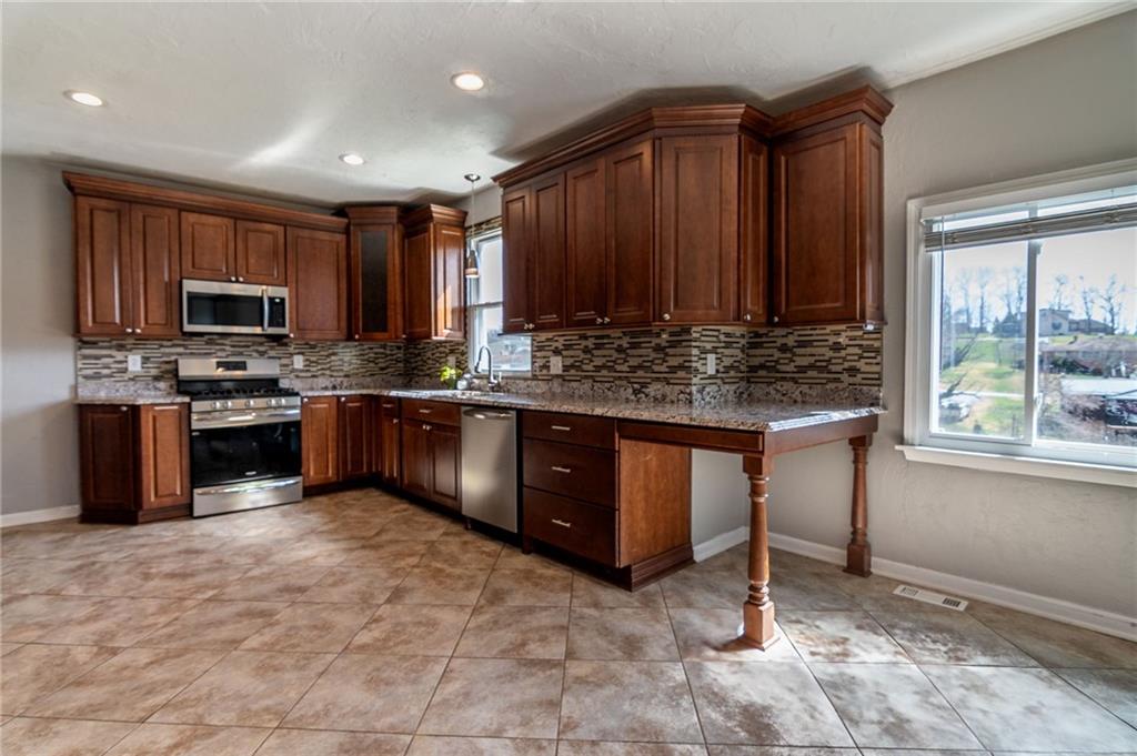 2541 Clay Pike Irwin, PA 15642 - Photo 12 of 36 a kitchen with stainless steel appliances granite countertop a stove a sink dishwasher and a refrigerator