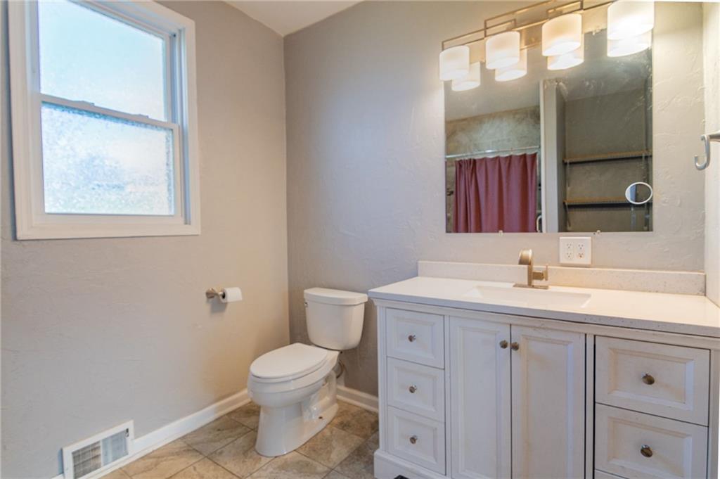 2541 Clay Pike Irwin, PA 15642 - Photo 16 of 36 a bathroom with a toilet a sink a vanity and mirror