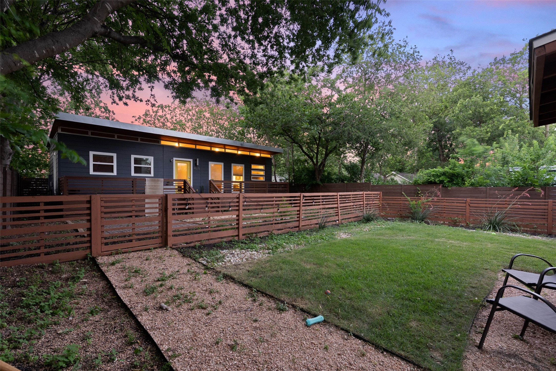 412 West Croslin Street Austin, TX 78752 - Photo 19 of 36 A private yard with a slatted fence surrounds this contemporary dark-clad residence, providing secluded outdoor living.
