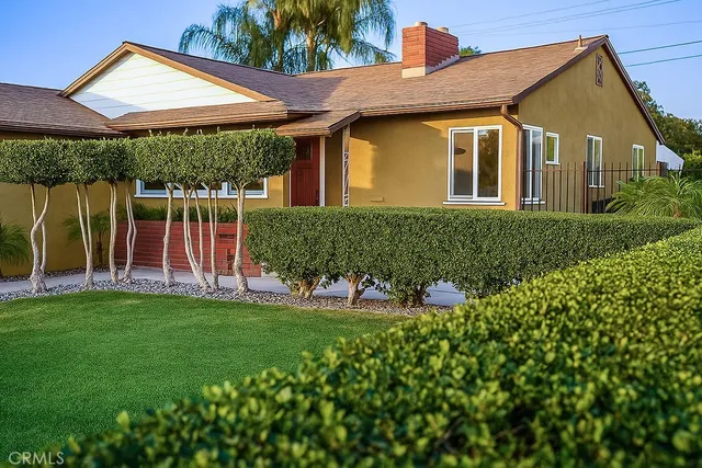 a front view of a house with a garden and plants