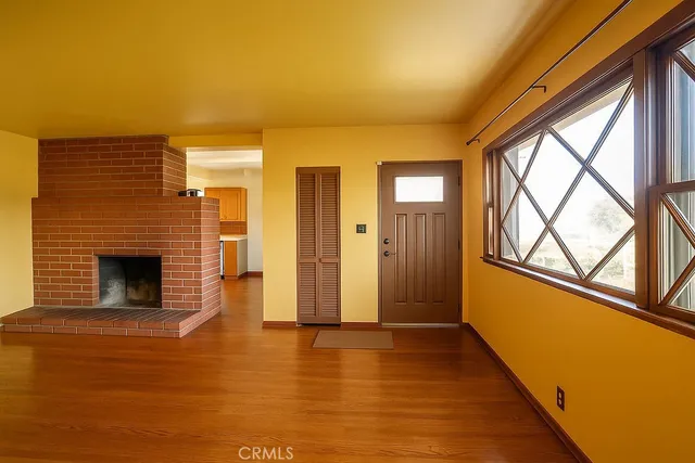 a view of an empty room with glass door and wooden floor