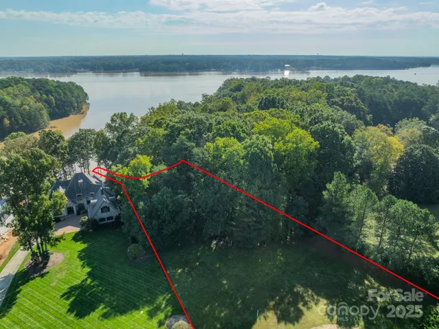 an aerial view of a house with a yard and lake view