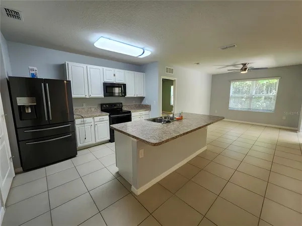 a kitchen with stainless steel appliances granite countertop a sink and a refrigerator