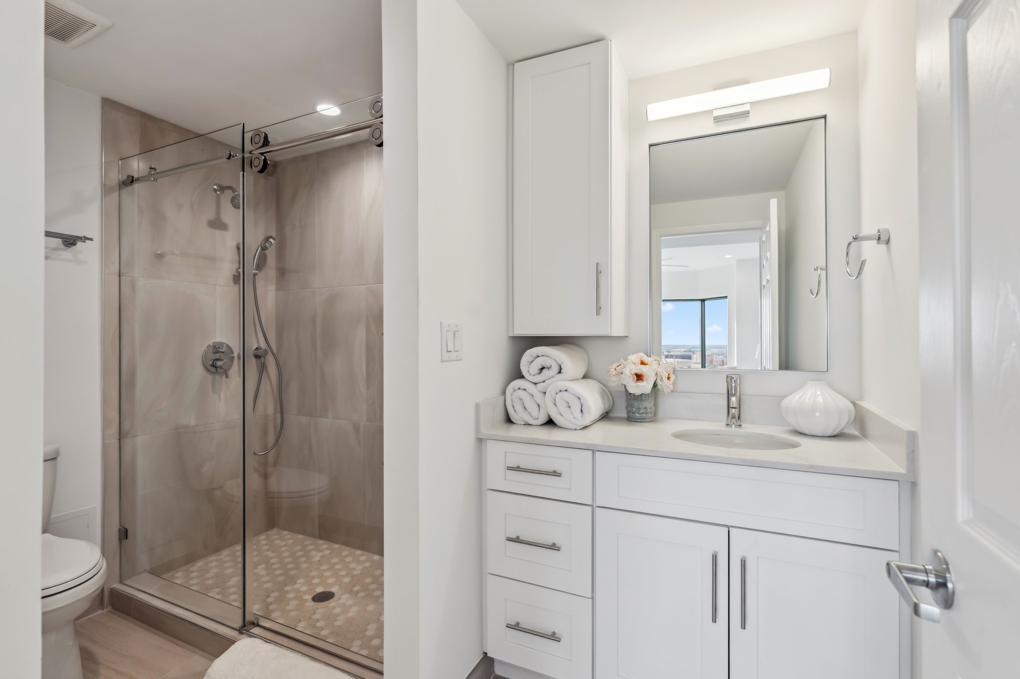 2001 Holcombe Boulevard, Unit 2305 Houston, TX 77030 - Photo 12 of 46 a en suite bathroom with a granite countertop sink mirror and shower