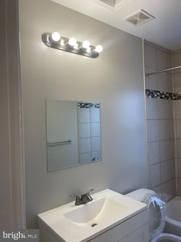 a bathroom with a sink a light fixture and a mirror