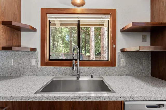 a kitchen with granite countertop a sink and a stove