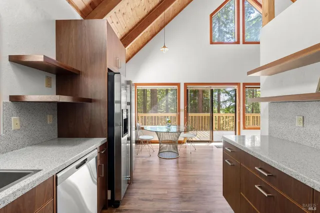 a kitchen with a wooden floor and a large window