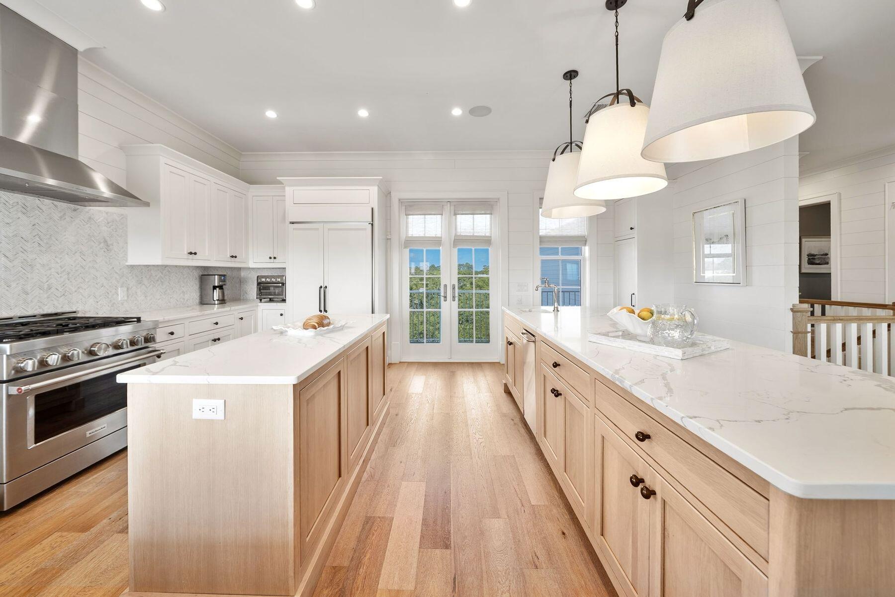 8183 East County Highway 30A Inlet Beach, FL 32461 - Photo 43 of 63 a large kitchen with stainless steel appliances a stove a sink a refrigerator and a dining table with wooden floor