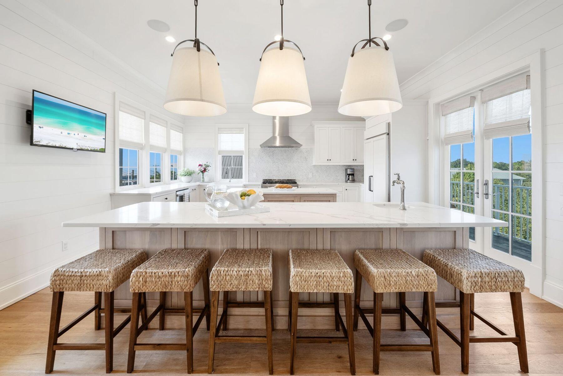 8183 East County Highway 30A Inlet Beach, FL 32461 - Photo 6 of 63 a kitchen with stainless steel appliances a dining table chairs and white cabinets