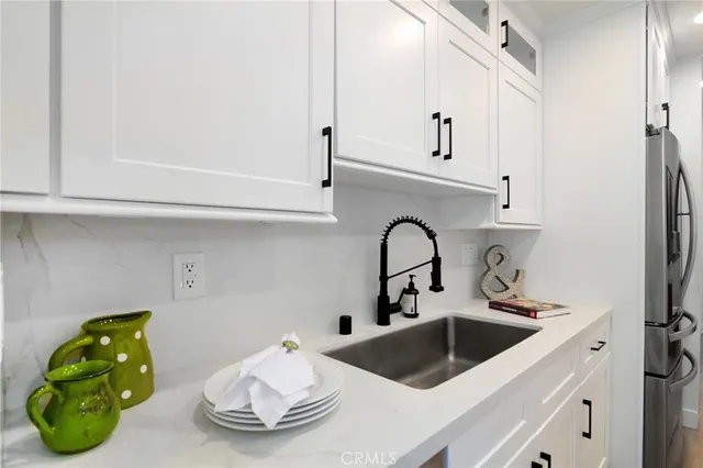 a kitchen with a sink a refrigerator and cabinets