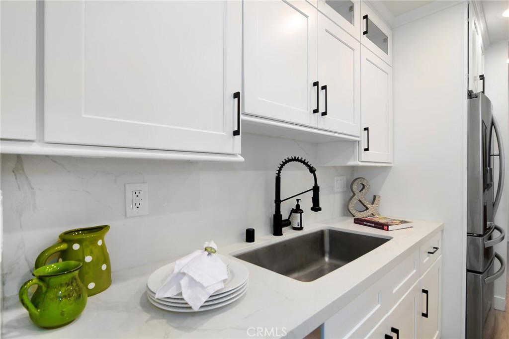 959 North Doheny Drive, Unit 205 West Hollywood, CA 90069 - Photo 11 of 25 a kitchen with a sink a refrigerator and cabinets