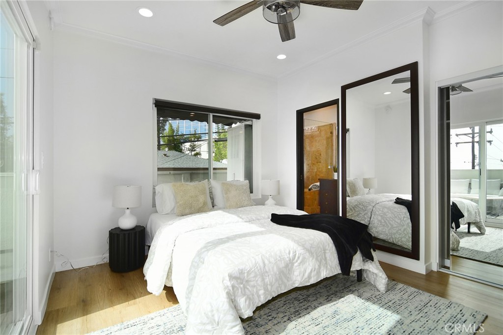 959 North Doheny Drive, Unit 205 West Hollywood, CA 90069 - Photo 16 of 25 a bedroom with a bed and wooden floor