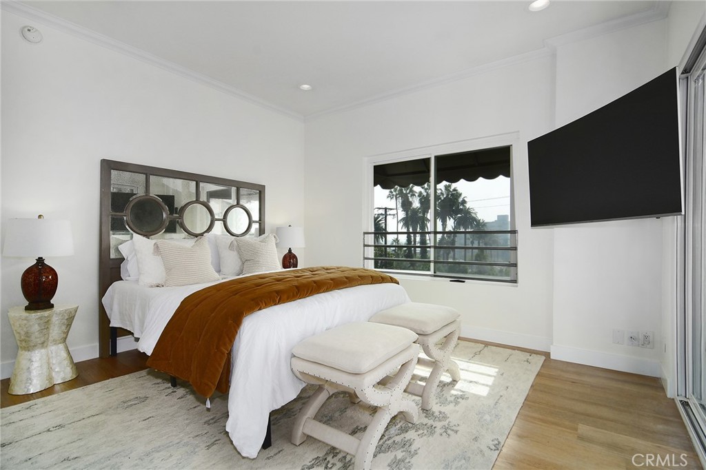 959 North Doheny Drive, Unit 205 West Hollywood, CA 90069 - Photo 18 of 25 a bedroom with a bed and a flat screen tv