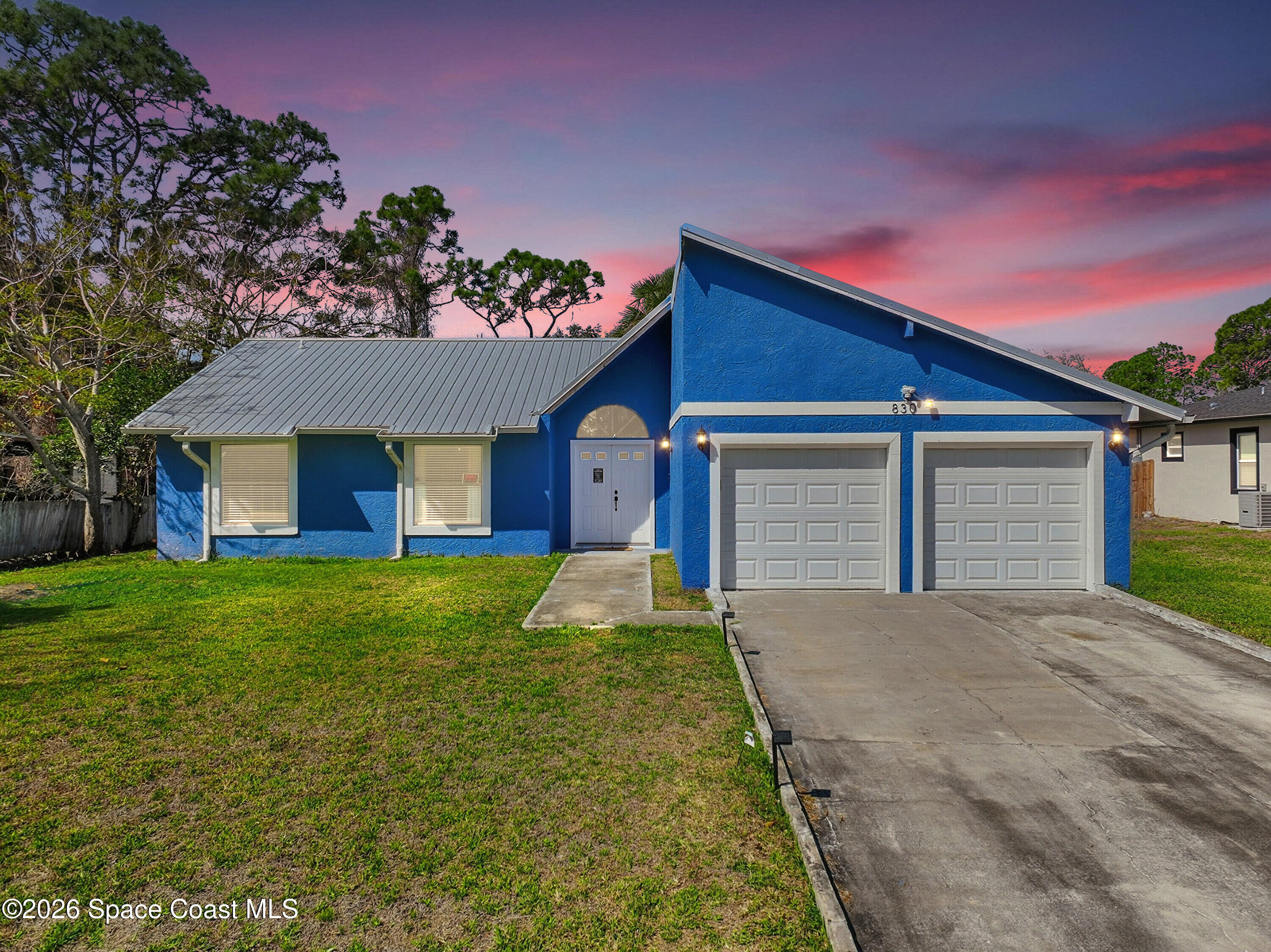 830 Garvey Road Palm Bay, FL 32908 - Photo 1 of 48 a front view of a house with a yard and garage