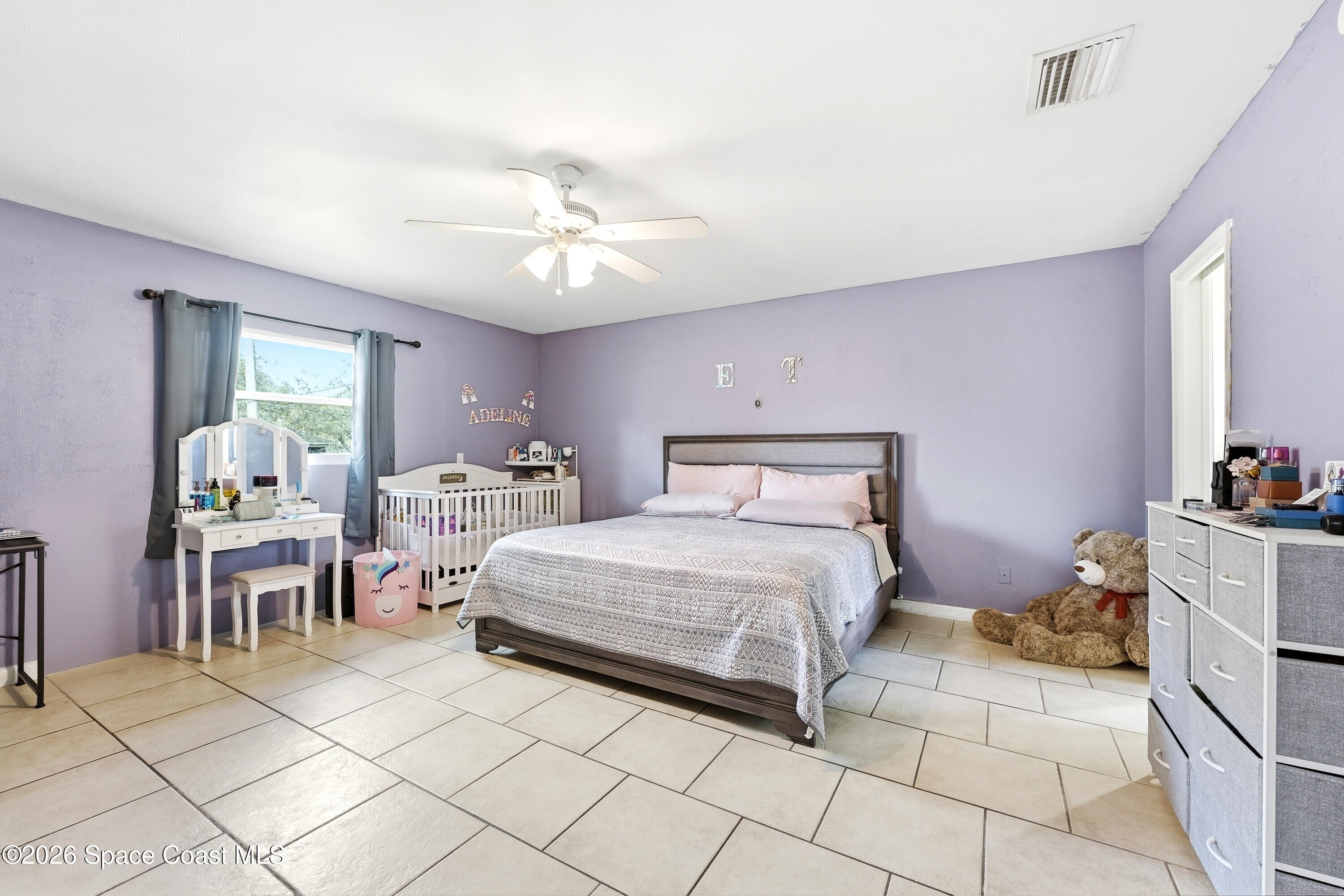 830 Garvey Road Palm Bay, FL 32908 - Photo 17 of 48 a bedroom with a bed and a table in it with window